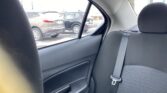 Backseat of a car with a raised seatbelt, view out the side window to parked SUVs in a snowy parking lot