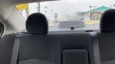 Rear car seats with headrests, viewed from the back seat, looking out to a dealership lot through the rear window