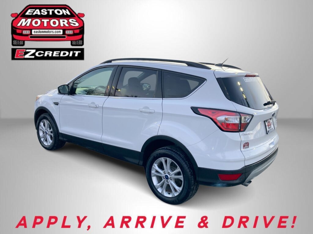 White SUV with roof rails beside the Easton Motors EZ Credit logo; red 'Apply, Arrive & Drive' slogan at bottom.