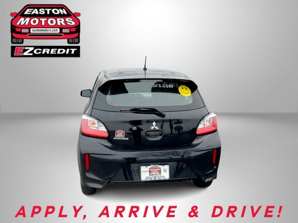 Rear view of a black hatchback with an Easton Motors logo on the wall to the left and a yellow smiley sticker on the rear window; bottom text reads 'APPLY, ARRIVE & DRIVE!'