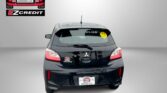 Rear view of a black hatchback with an Easton Motors logo on the wall to the left and a yellow smiley sticker on the rear window; bottom text reads 'APPLY, ARRIVE & DRIVE!'