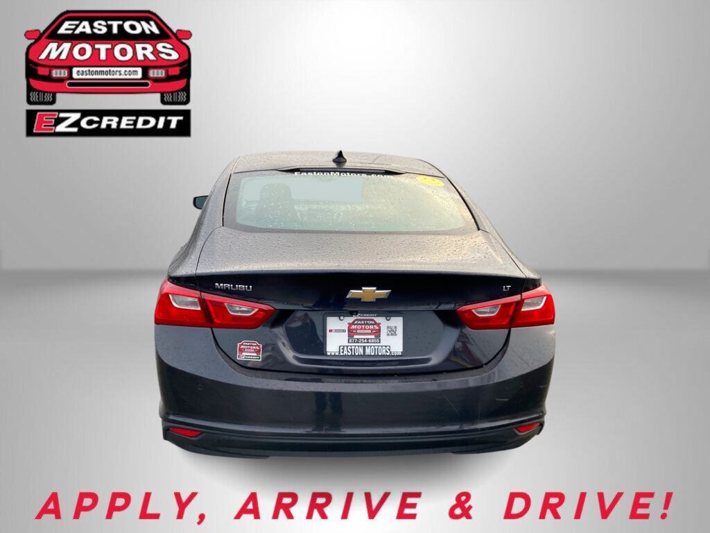 Rear view of a black Chevrolet Malibu with EZCredit logo on the left and dealership plates, rain on the car window, and a bold 'APPLY, ARRIVE & DRIVE!' phrase at the bottom.