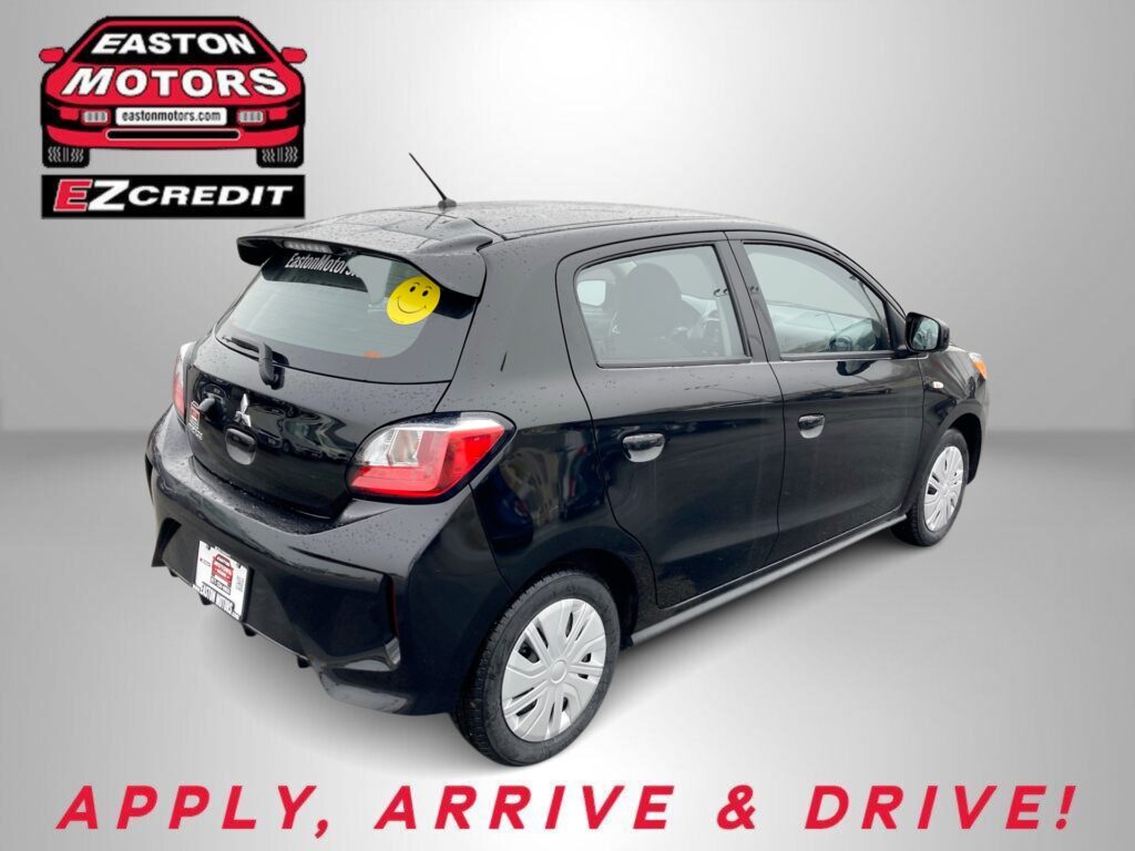 Dark hatchback car with rain droplets parked indoors; Easton Motors logo on the wall and a large 'EZCredit' sign beside it. Text reads 'APPLY, ARRIVE & DRIVE!' at the bottom.