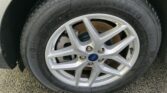 Close-up of a car tire mounted on a silver alloy wheel with a Ford center cap and a visible brake rotor behind it.