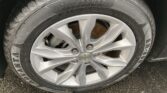 Close-up of a wet car tire mounted on a silver alloy wheel with a Chevrolet emblem at the center; tire sidewall shows size 225/55R17.
