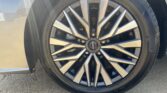 Close-up of a car wheel with a multi-spoke alloy rim and a Nissan center badge at the hub.