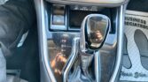 Gear selector area of a car: automatic transmission shifter showing P, R, N, D, with red P indicator; electronic parking brake button nearby; USB ports above and shiny trim around the console.