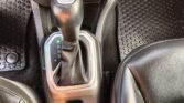 Automatic gear shift lever in center console with engine start/stop button and cup holders nearby