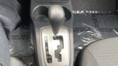 Center console of a car showing automatic gear shifter with Park gear selected, cup holder, and surrounding area.