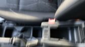 Blurry photo of a car interior showing black seats and red seat belt buckles.