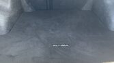 Dark car trunk/cargo area with carpeted floor and an 'ALTIMA' emblem on the floor mat