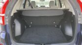 Open SUV trunk with cargo cover and folded rear seats, showing spacious cargo area in a blue vehicle