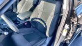 Front seat area of a car with two black fabric seats, center armrest, and visible seat belts