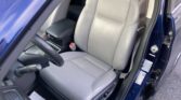 Front driver and passenger seats in gray perforated leather, inside a blue car, with the steering wheel and center console visible.