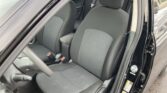 Interior of a dark sedan showing the front driver and passenger seats, headrests, and an open door on the right side of the image