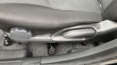 Car seat bottom showing fabric upholstery and a metal adjustment lever near the seat base