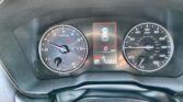 Instrument cluster view: left tachometer, right speedometer, center alert showing a car with red border and door-open indicators (vehicle alert).