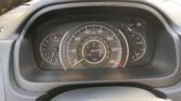 Close-up of a car dashboard showing the tachometer, speedometer, and central digital display with trip data and outside temperature.