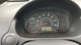 Car dashboard with speedometer up to 140 mph, tachometer on left, and digital odometer showing mileage; steering wheel in view.