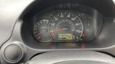 Close-up of the car's instrument cluster: speedometer up to 140 mph, tachometer on the left, and a digital display reading 018874 miles with warning lights.