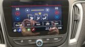 Touchscreen climate control panel in a car, showing HI/LO temps, fan icons, and On/Off, A/C, Auto, Sync buttons on the display edge.