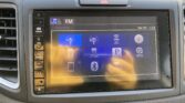 In-car touchscreen showing FM radio interface with icons for iPod, Pandora, Bluetooth, and HDMI.