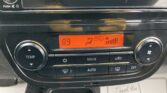 Car climate control panel with an orange display showing 89°, left temperature dial, and right fan/airflow controls with MODE and AUTO buttons nearby.
