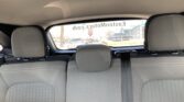 Rear seat view showing gray fabric upholstery and headrests, with a street scene visible through the rear window.