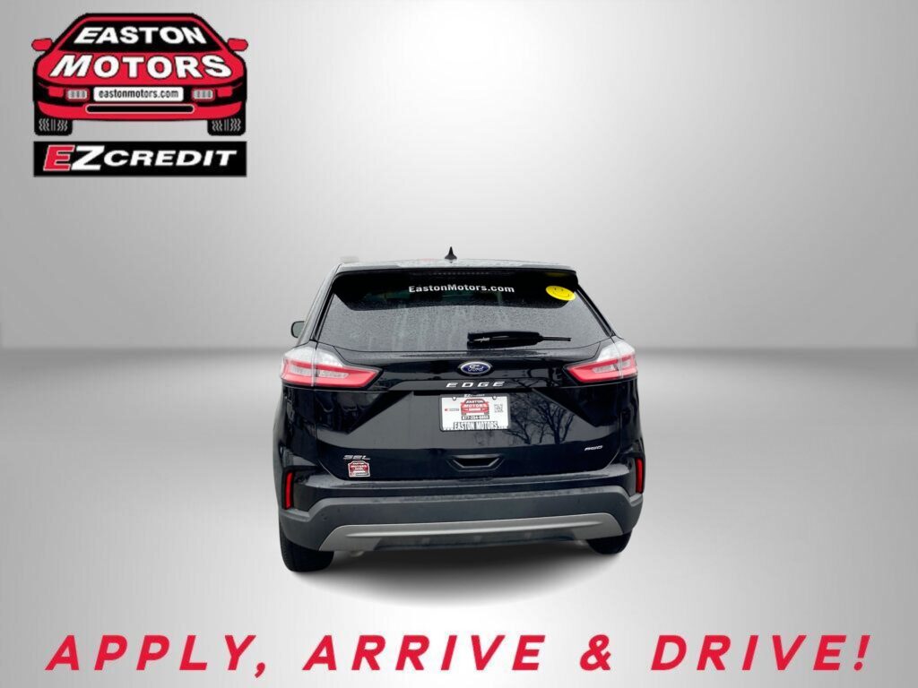 Rear view of a black Ford SUV with a dealership logo in the top left and a bold 'APPLY, ARRIVE & DRIVE!' banner at the bottom.