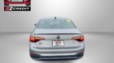 Rear view of a gray VW Jetta with Easton Motors branding on the windshield and the 'APPLY, ARRIVE & DRIVE!' slogan at the bottom of the image.
