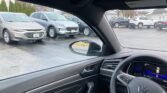 View from the driver’s seat of a car parked in a lot, with other vehicles visible through the windshield and side window