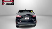 Rear view of a black Ford SUV with a dealership logo in the top left and a bold 'APPLY, ARRIVE & DRIVE!' banner at the bottom.