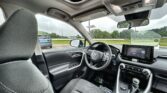 Interior of a car showing the steering wheel, center touchscreen, gear shifter, and sunroof from the front seat view.