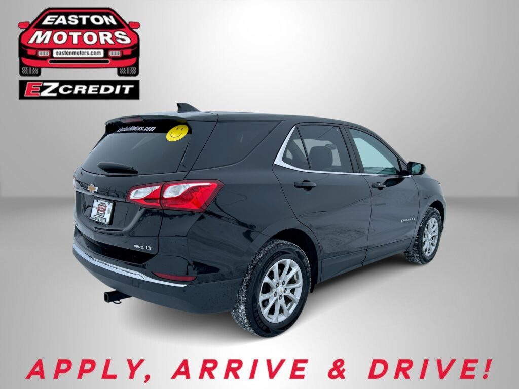 Rear three-quarter view of a dark-gray SUV with a yellow smiley sticker on the rear window, Easton Motors EZ Credit logo on a gray backdrop, and 'APPLY, ARRIVE & DRIVE!' text at the bottom.