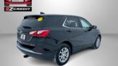 Rear three-quarter view of a dark-gray SUV with a yellow smiley sticker on the rear window, Easton Motors EZ Credit logo on a gray backdrop, and 'APPLY, ARRIVE & DRIVE!' text at the bottom.
