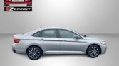 Side view of a silver sedan against a gray background with Easton Motors logo and EZCredit branding; red 'APPLY, ARRIVE & DRIVE!' text at bottom.