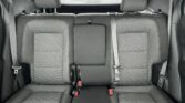 Rear car seat row with three seat cushions, two outer headrests, and three-point seatbelts.