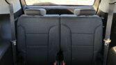 Car interior rear seating with two headrests, dark patterned upholstery, and visible seat belts