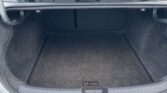 Open trunk of a Volkswagen, showing a dark carpeted cargo area with a small CarGo Protection label on the floor mat.