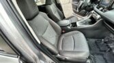 Front interior of a car with two gray cloth seats, center console, and steering wheel; driver's door is open.