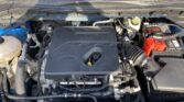 Front view of a vehicle's engine bay with an EcoBoost cover, battery on the right, and various hoses and reservoirs visible.