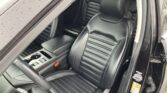 Black leather front seats with horizontal stitching and a center console in a car interior.