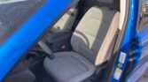 Open blue car door reveals the front driver’s seat in gray cloth with headrest and visible steering wheel.