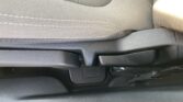 Car seat with fabric upholstery and a manual lever/adjustment mechanism at the side for reclining or sliding the seat edge.