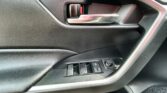Car interior door panel with a chrome door handle and window control buttons along the armrest, textured black surface.