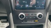 Car infotainment/climate control panel with touchscreen showing automatic climate control (83° left, 81° right) and fan icons; physical VOL and TUNE knobs below, hazard button in center.