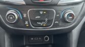 Center console climate control panel: hazard button above, central buttons for defrost/air flow, warm/cool dials on sides, and a dual-arrow airflow graphic in the middle.