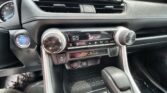 Car dashboard and center console with climate control set to 69°F, gear selector in Park, and a blue power button on the left panel.
