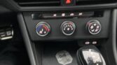 Center console: three climate control dials with a gear shifter to the right; hazard light button above.