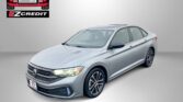 Gray sedan angled in foreground with Easton Motors EZ Credit logo in the top-left and 'APPLY, ARRIVE & DRIVE!' text along the bottom surface area.